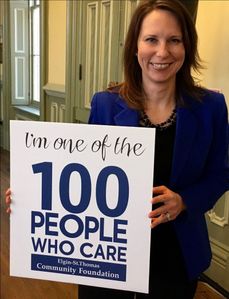 Holding a sign that reads I’m one of the 100 People Who Care