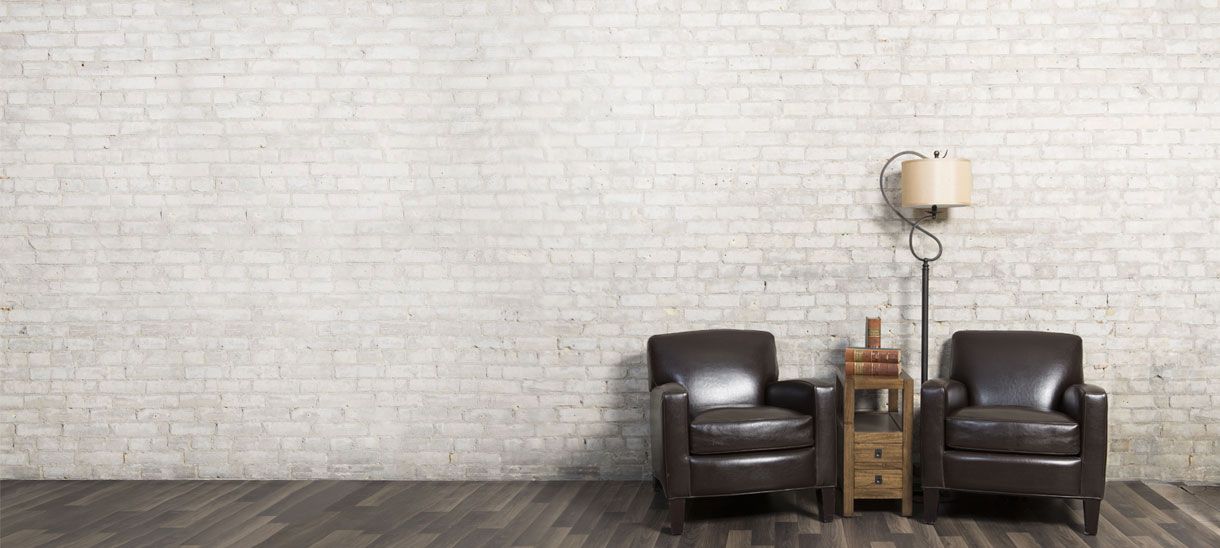 Two leather armchairs and a side table under a floor lamp